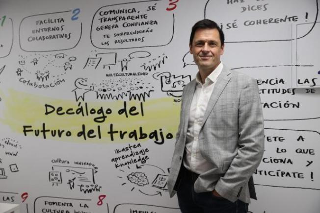 Alex Uriarte frente al mural de la sede